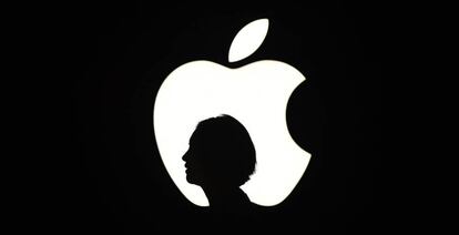 La silueta de una mujer junto a un logo de Apple en un evento en San Francisco. 