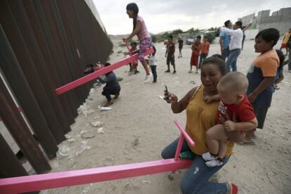 El Gobierno mexicano afirma que sin su cooperación llegarían este año 250.000 migrantes sin papeles a territorio estadounidense. En la imagen, una madre y su hijo juegan junto a la valla en Ciudad Juárez.