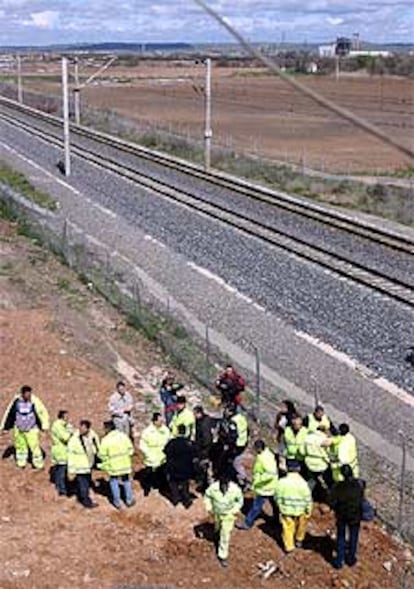 Guardias civiles y operarios de Renfe, junto a las vías del AVE Madrid-Sevilla donde fue hallada la bomba.