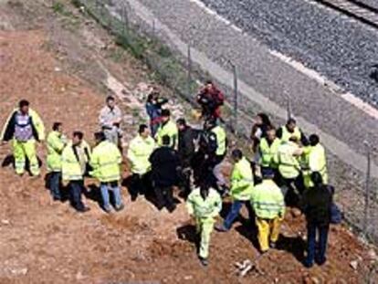 Guardias civiles y operarios de Renfe, junto a las vías del AVE Madrid-Sevilla donde fue hallada la bomba.