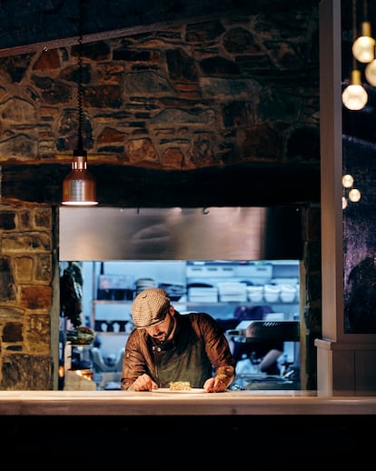 El chef Yordi Martínez en la zona de emplatado y pase de L’Antiquari Gastronòmic, en el barrio de Gràcia de Barcelona.