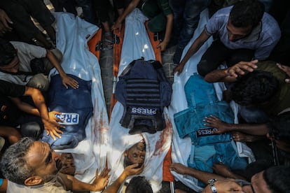 Varias personas durante la ceremonia funeraria para los periodistas asesinados por un ataque israelí contra el hospital Nasser, en el sur de Gaza, este lunes.