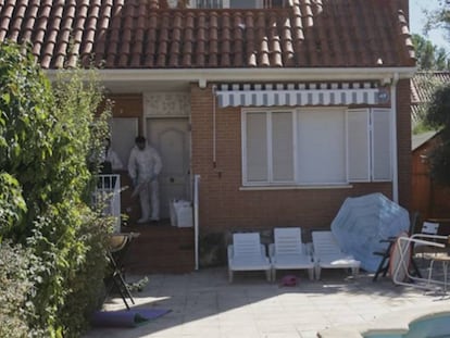 Forensic experts inspect the house where the four bodies were found.