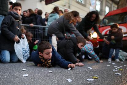 Un grupo de niños recoge los caramelos lanzados durante la cabalgata de Granada.