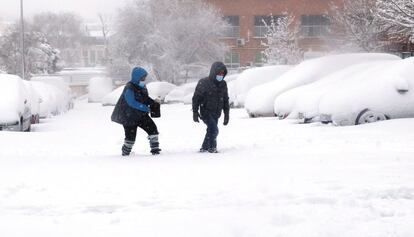 Dos personas caminan por la calle, tras las nevada caída en Villaverde Bajo (Madrid).