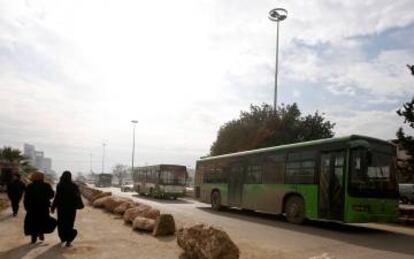 Unos autobuses vacíos abandonan la zona de evacuación.