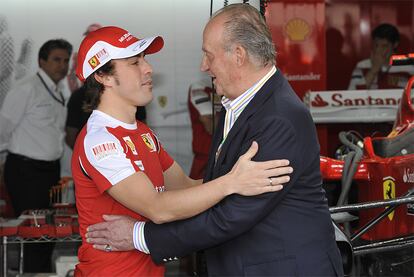 El rey Juan Carlos, seguidor de la fórmula uno, saluda a Fernando Alonso en los momentos previos a la carrera