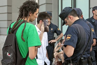 Agentes de policía controlan la documentación de unos jóvenes en las inmediaciones de la plaza de Neptuno.