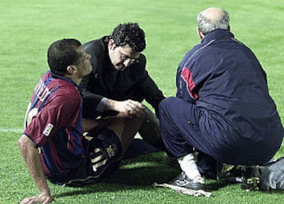 Rivaldo recibe la atención del médico y del masajista del Barça, el sábado, en Balaídos.