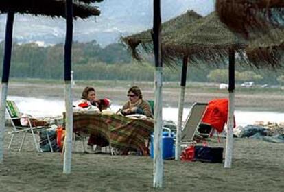 Dos turistas, ayer, en la playa de Guadalmar (Málaga).