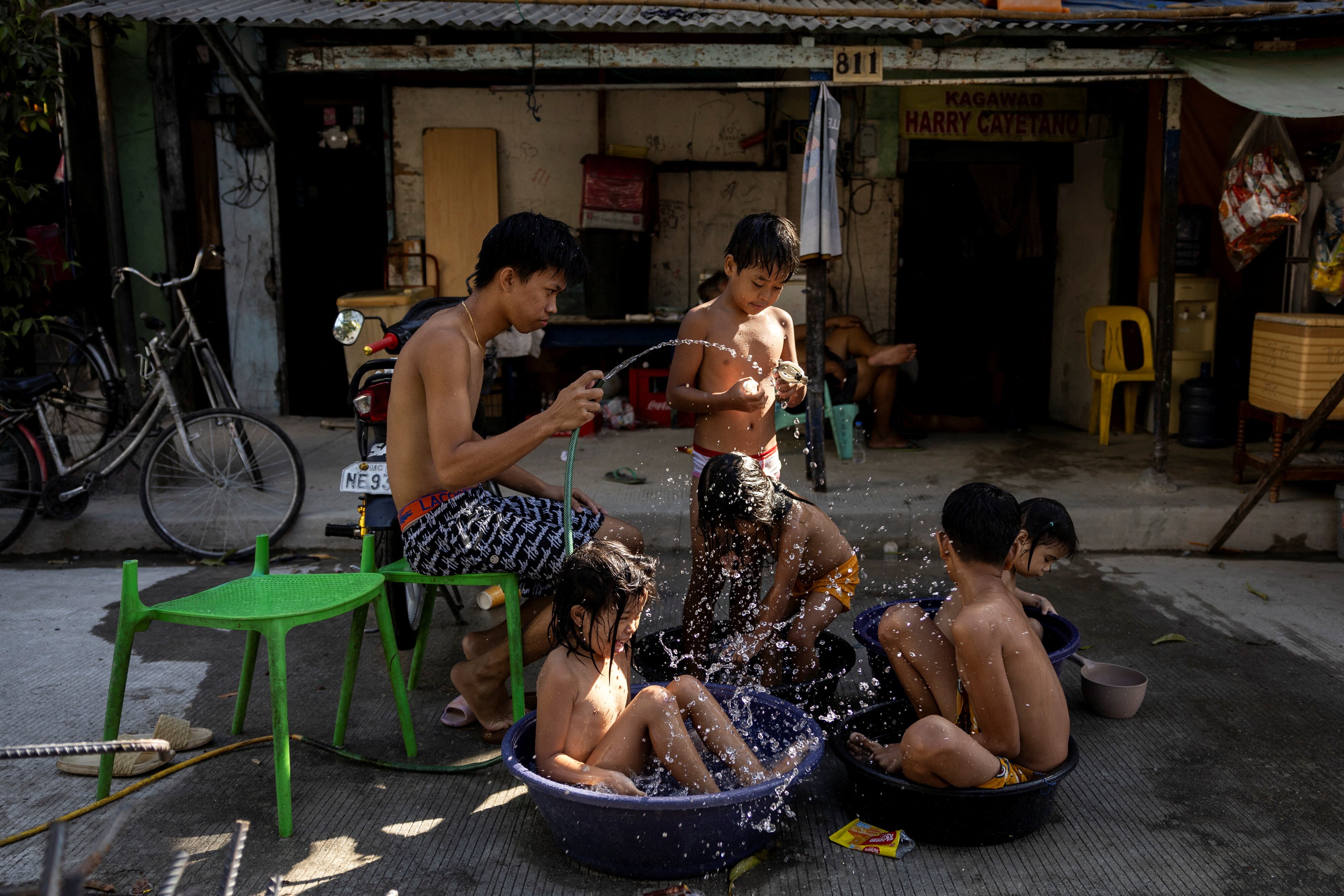 Varios niños se refrescaban el lunes en una calle en Manila. 