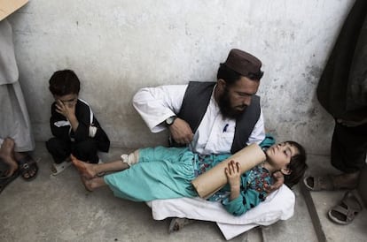 Un hombre sujeta a su hija de 8 a&ntilde;os mientras espera en el hospital Boost de Lashkar Gah, en la provincia de Helmand.
 