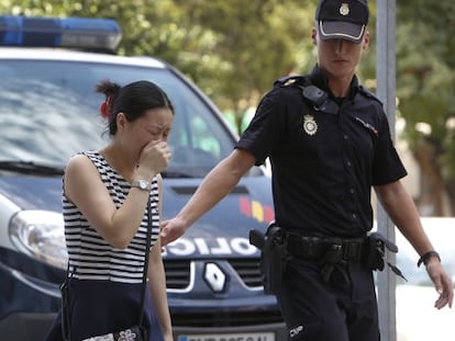 Una mujer llora junto al lugar donde fueron asesinadas una mujer y su nieta, supuestamente por una familiar esquizofr&eacute;nica.  