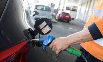 Un empleado echa combustible a un cliente en una gasolinera de Madrid.