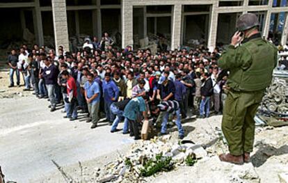 Soldado israelí vigilando a palestinos detenidos