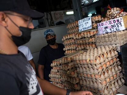 Trabajadores atienden un local de alimentos en un mercado de Caracas.