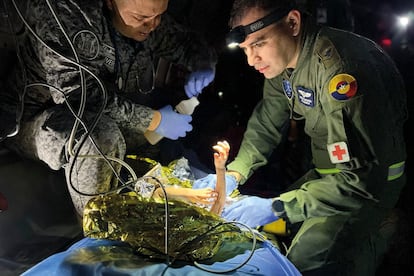 Dos mdicos de las fuerzas militares de Colombia atienden a uno de los ni?os rescatados de la selva amaznica durante el traslado areo a Bogot, el 10 de Junio del 2023.