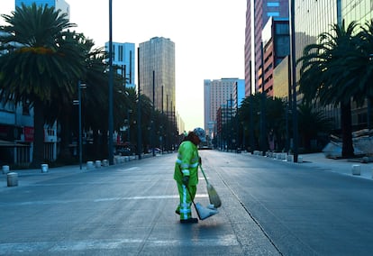 Trabalhador limpa rua vazia na Cidade do México.