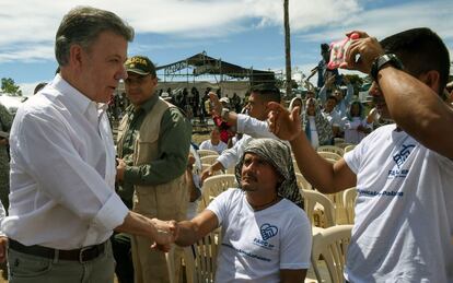 El presidente colombiano Juan Manuel Santos (i) saluda a miembros de las FARC durante el evento de conmemoración de fin del grupo armado en Buenavista. 