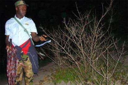 Feliciano Sampa husmea entre los matorrales con su linterna durante su ronda nocturna.