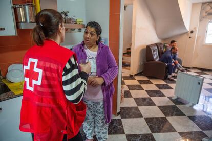 Anna Terres, de Cruz Roja, charla con Rosa Giménez en su casa de El Raval, en Algemesí, tras entregarle una estufa y un deshumidificador. 
