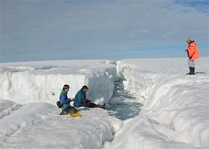 Tres científicos miden la salinidad, la temperatura y la profundidad de la fractura del bloque de hielo, en julio de 2002.