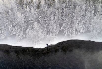 Un hombre pesca en la orilla del río Yenisei, cubierto de nieve y escarcha, en la ciudad siberiana de Krasnoyarsk (Rusia).