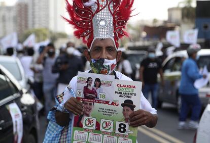 Un simpatizante de la candidata presidencial Verónika Mendoza del partido Juntos por Perú sostiene un calendario con su foto durante un evento de campaña en Lima, el 6 de abril de 2021.