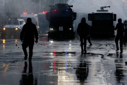 Manifestantes chocan con la policía en la Alameda, en Santiago, este viernes mientras el presidente Boric daba su primer discurso desde el palacio de La Moneda.