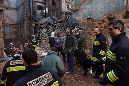 Los bomberos buscan posibles víctimas entre los restos del edificio derrumbado.