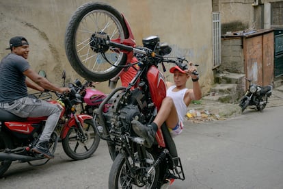 Gabriel Bastidas con otros jóvenes, practican sus trucos en sus motos en callejones de El Valle, Caracas (Venezuela). 