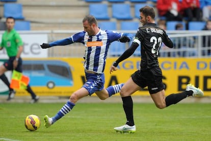 El jugador del Alavés Despatovic realiza un lanzamiento ante la presencia de Delgado, del Leganés.