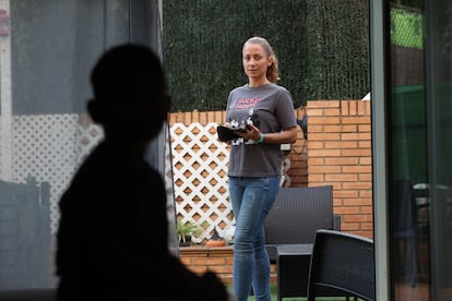 Liam en primer plano en sombra y su madre, Yolanda Montero, en el jardín de su casa en Móstoles, con el medidor de azúcar en la mano.