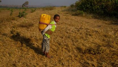 Una niña etíope carga con un contenedor de agua en su espalda.