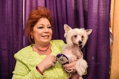 La dueña de un crestado chino posa entre las bambalinas del concurso. El crestado chino es un perro alopécico de cuerpo y peludo de cabeza que suele estar entre los favoritos a ganar el concurso, también estadounidense, de perro más feo del mundo.