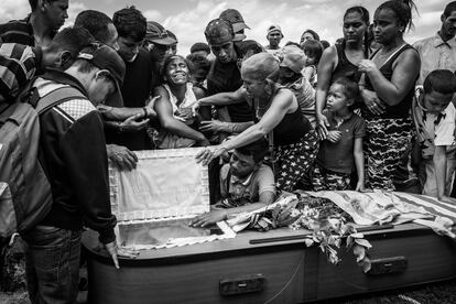 Una mujer llora durante el funeral de su marido, Keiber Cubero (25 años). Padre de una niña, Keiber salió una noche junto con otros dos compañeros a robar comida en un restaurante, pero fueron interceptados y abatidos a tiros por la policía. El 95% de los homicidios en Venezuela quedan impunes.