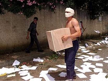 Un manifestante enmascarado vacía una urna en Tizi Uzu, capital de la Cabilia argelina.