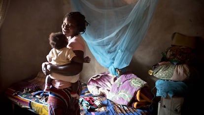 Una madre y su bebé ante una mosquitera azul. “Puedes tener medicinas y mosquiteras, pero el reto es cómo trabajas con los países para implementar estas herramientas”, explica la presidenta y directora ejecutiva de Jhpiego, Leslie Mancuso. Jhpiego implementará el proyecto Tiptop financiado por Unitaid.