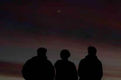 Tres personas observan el alineamiento de Júpiter y Saturno con la Tierra el pasado lunes en Kansas.