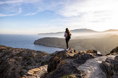 Beautiful woman standing on a cliff during sunset with the mediterranean sea in the background at Cap de Creus, in Spain (Libertad financiera - Sabadell)