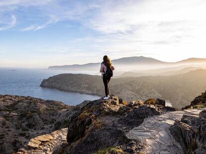 Beautiful woman standing on a cliff during sunset with the mediterranean sea in the background at Cap de Creus, in Spain (Libertad financiera - Sabadell)