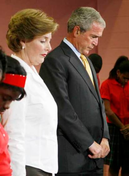 Bush y su mujer rezan con unos escolares.