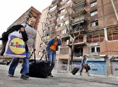 Los vecinos del inmueble de la calle Andrade de Barcelona, afectado por una explosión que ayer causó la muerte a tres personas, recogen sus pertenencias para ser alojados en hoteles o en casas de familiares.