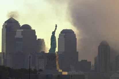 2001: una nube de polvo envuelve la estatua y lo que fue el Wolrd Trade Center tras el derrumbe de las Torres Gemelas el 11-S.