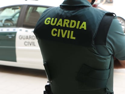 Un agente de la Guardia Civil, de espaldas, junto a un vehículo oficial en una imagen de archivo.