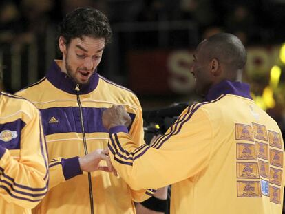 Los jugadores de Lakers Pau Gasol y Kobe Bryant miran sus anillos de campeones de la NBA durante la ceremonia de entrega en octubre de 2010.