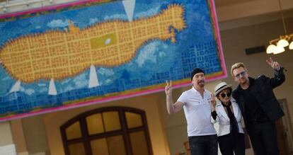 The Edge, Yoko Ono y Bono, frente al tapiz en memoria de John Lennon en el museo de Ellis Island 