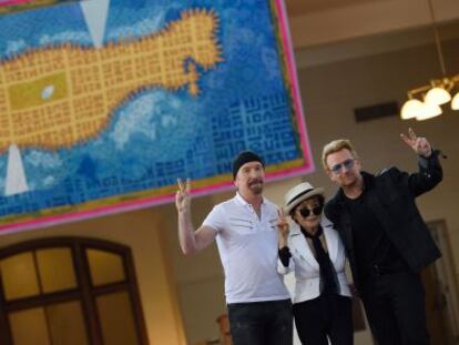 The Edge, Yoko Ono y Bono, frente al tapiz en memoria de John Lennon en el museo de Ellis Island 