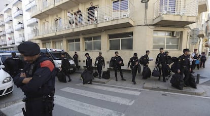 Un grupo de agentes de la Policía espera su transporte frente al hotel Mont-Palau de Pineda de Mar.