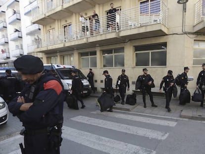 Un grupo de agentes de la Policía espera su transporte frente al hotel Mont-Palau de Pineda de Mar.